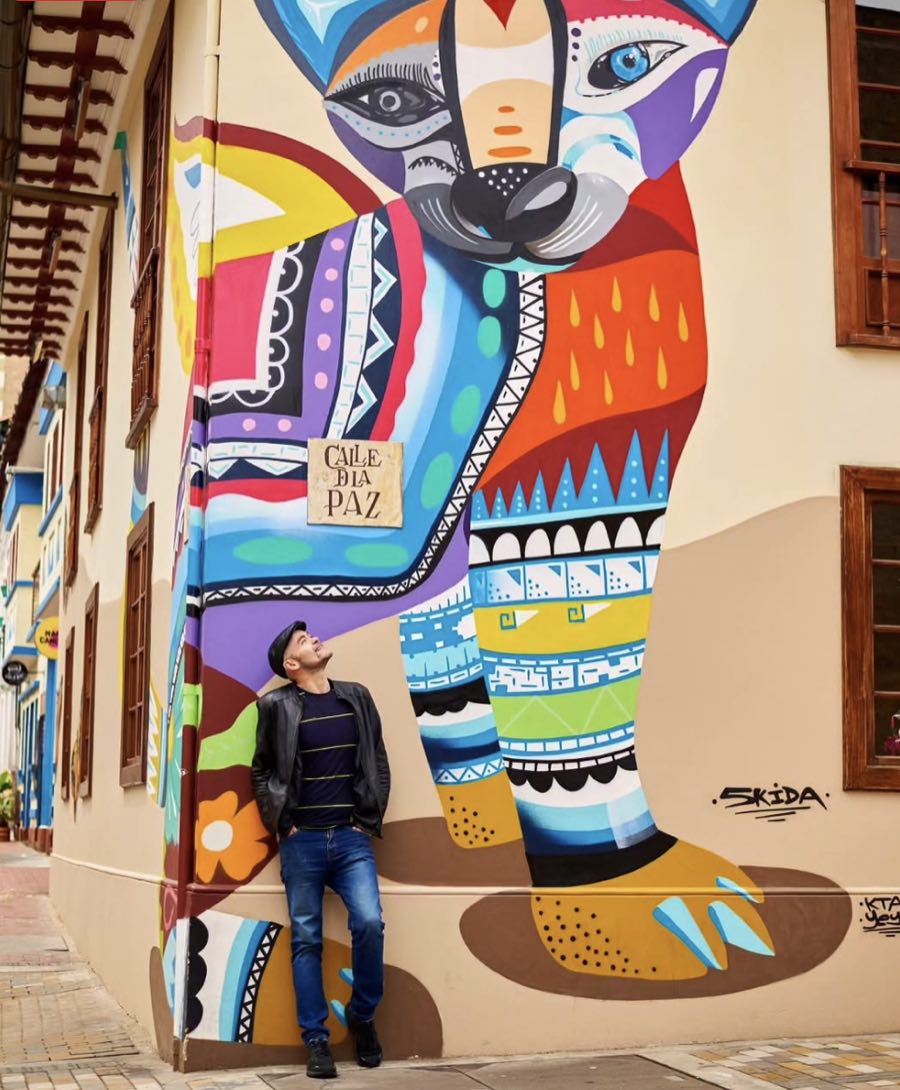 Travel Planner Colombie devant une fresque colorée pendant un premier voyage en Colombie